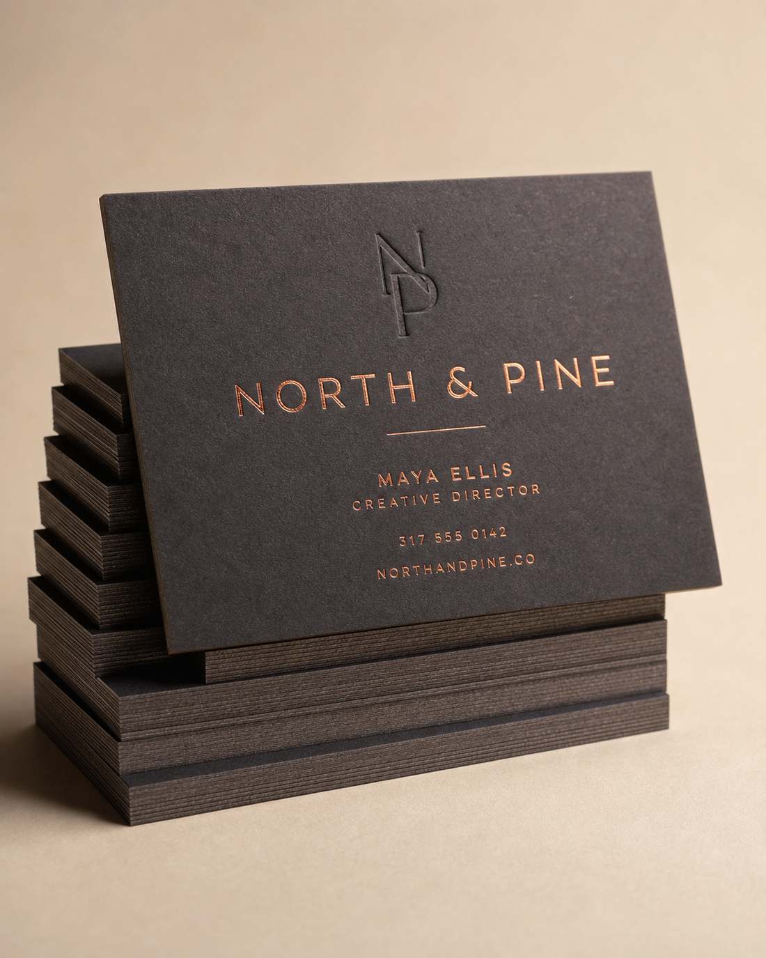 Stack of dark business cards with copper foil lettering