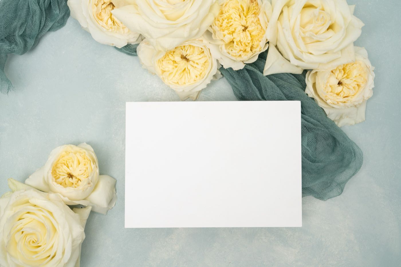 Flat lay of letterpress wedding invitations with blush envelopes and ribbon